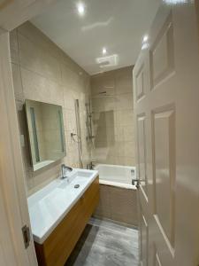 een badkamer met een bad, een wastafel en een bad bij Penthouse APT8 in Wolverhampton