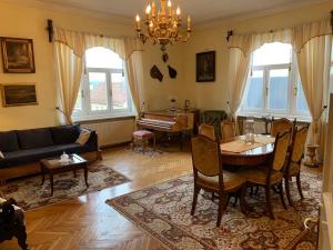 sala de estar con mesa y piano en The Marchburg Apartment, en Maribor