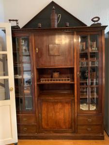 a wooden cabinet with glass doors in a room at The Marchburg Apartment in Maribor