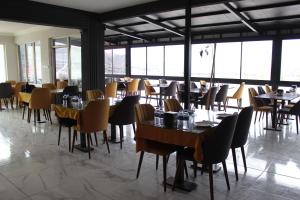 a dining room with tables and chairs and windows at TOPCUOĞLU GRAND OTEl in Gerede