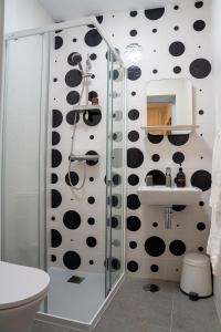 a bathroom with a shower with black and white polka dots at Hostal Tarantelo Conil in Conil de la Frontera
