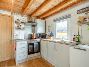 a kitchen with white cabinets and a sink and a window at Pendle View Lodge in Altham