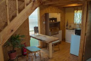 cocina con mesa de madera y nevera en Agroturismo mapuweñimen, en San Fernando