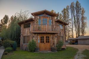 a wooden house with a balcony on top of it at Agroturismo mapuweñimen in San Fernando