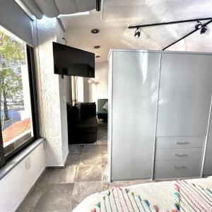 um quarto com uma televisão e uma cómoda num quarto em Departamento tipo LOFT cerca de hospital Angeles em Cidade do México