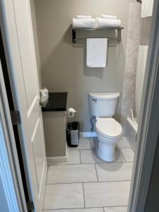 La petite salle de bains est pourvue de toilettes et de serviettes. dans l'établissement Royal Inn Eugene- Airport, à Eugene