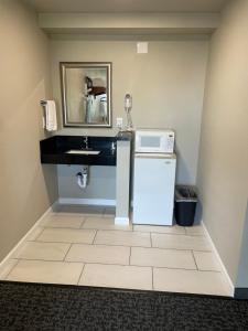 a small bathroom with a sink and a microwave at Royal Inn Eugene- Airport in Eugene