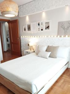 a bedroom with a large white bed with lights on the wall at Natural Charm Apartment in Rome