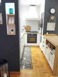 a kitchen with white cabinets and a rug on the floor at Natural Charm Apartment in Rome