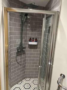 a bathroom with a shower with a glass door at The Snug@Bournville in Birmingham