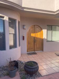 a home with a wooden door and a patio at Private room in Awesome Sonoma Ranch Home in Las Cruces