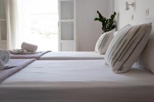 un letto bianco con due cuscini e una finestra di Seample studios a Chrissi Akti