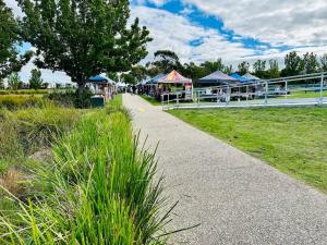 a walkway in a park with tents and grass at Spacious modern family home in Pakenham