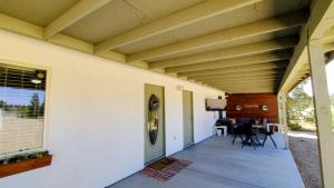a house with a porch with a wooden ceiling at Falcon Cottage in Pahrump