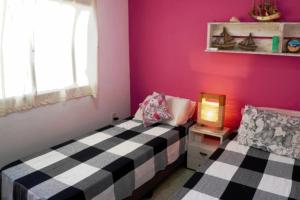 a room with two beds and a pink wall at El Arrayan in Tacuarembó