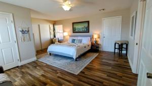 a bedroom with a bed and a wooden floor at Falcon Cottage in Pahrump +32 photos