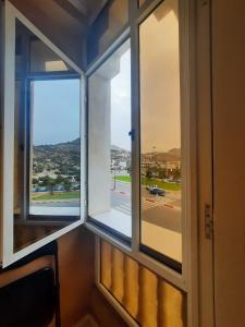 a room with two windows with a view of a street at Hôtel ALMUNECAR in Al Hoceïma