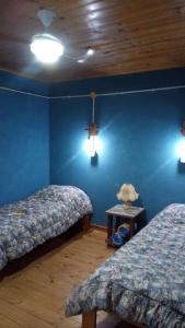 a bedroom with two beds and a blue wall at Lo de la Abuela in Goya