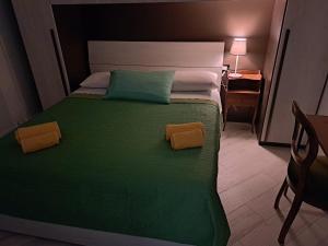a bedroom with a green bed with two pillows on it at Your Comfort Home - Bologna in Bologna
