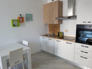 Your Comfort Home - Bologna في بولونيا: مطبخ بدولاب بيضاء وطاولة بيضاء