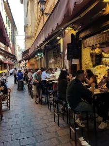 a group of people sitting at tables in a restaurant at Your Comfort Home - Bologna in Bologna