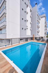 an image of a swimming pool in front of a building at 2 QUARTOS com Churrasqueira na Varanda, Piscina, Garagem interna, WiFi 500mbps, Ar Condicionado e Telas de Proteção in Ubatuba