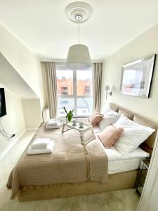 um quarto com uma cama grande e uma janela em Apartament Szafarnia DeLux em Gdańsk