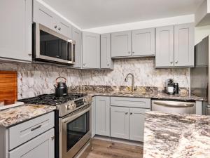 a white kitchen with granite counter tops and appliances at Hyatus at City Views in Bethlehem