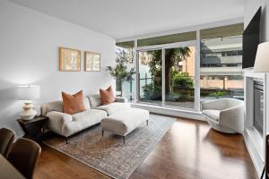ein Wohnzimmer mit einem Sofa, Stühlen und Fenstern in der Unterkunft Falls Pond Retreat by Iris Properties! in Victoria
