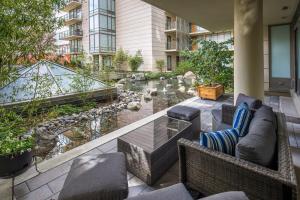 eine Terrasse mit Gartenmöbeln und einem Teich in der Unterkunft Falls Pond Retreat by Iris Properties! in Victoria