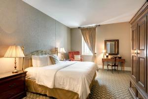 a bedroom with a white bed and a desk and a window at Nicollet Island Inn in Minneapolis