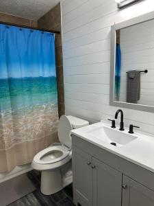 baño con aseo y lavabo y ventana en Beautiful House Sleeps 12 - Hot Tub - Walk to Beach, en Panama City Beach