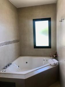 baño con bañera grande y ventana en San Lorenzo Premium en San Lorenzo
