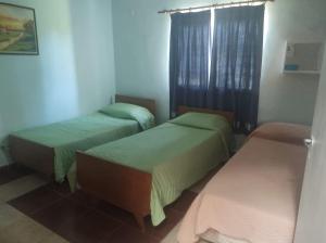 Cette chambre comprend 2 lits et une fenêtre. dans l'établissement El Desafío, à Santa Ana