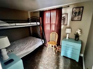 1 Schlafzimmer mit 2 Etagenbetten, einem Schreibtisch und einem Stuhl in der Unterkunft The “Bear” waterfront cabin in Muskoka in Utterson