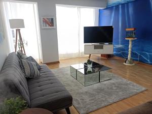 uma sala de estar com um sofá e uma televisão de ecrã plano em Miraflores View em Lima