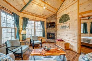 een woonkamer in een blokhut met een bed en een open haard bij Greenbrier Beechhouse Luxury Treehouse in Greenbrier