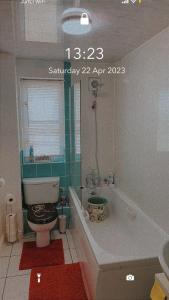 a bathroom with a toilet and a bath tub at Lovely 2 Bed Flat/Apt in East London- Nice Estate. in Dagenham