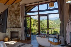 a large bathroom with a tub and a fireplace at Monte Mauá Chalés in Visconde De Maua