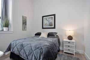 a white bedroom with a bed and a night stand at The National on Queen in Saint Marys