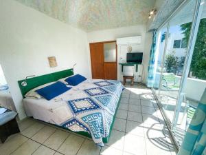 a bedroom with a bed and a balcony with a desk at Hotel Allende in La Paz