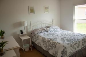a white bedroom with a bed and a window at Florida Escape in Orlando