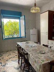 cocina con mesa con sillas y ventana en Casa vacanza selinunte, en Marinella di Selinunte