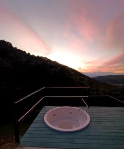a hot tub sitting on a deck with the sunset at Studio Suite Campestre con Jacuzzi in Buga