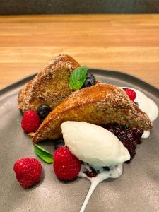 a plate of french toast with berries and whipped cream at Hotel Shibari - Restaurant & Cenote Club in Tulum