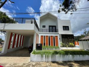 a white house with orange accents on it at Villa Qfa Syariah in Lembang