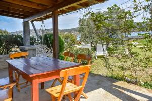 a wooden table and chairs on the porch of a house at House Zora in Otok Zizanj