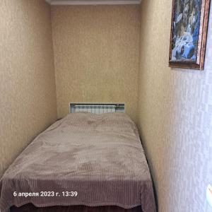 a bed in a corner of a bedroom with a picture on the wall at Квартира 5-9 in Aktau