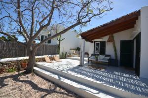 un patio con un albero e una casa di Can Taronger Menorca a Cala'n Forcat