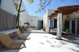 un patio con 2 sedie e un pergolato di Can Taronger Menorca a Cala'n Forcat